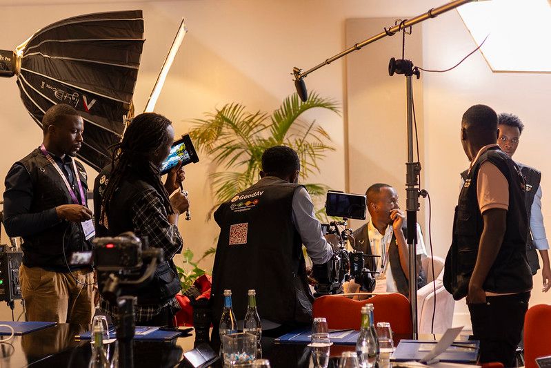 Professional camera crew with studio lighting and boom mic filming a corporate interview