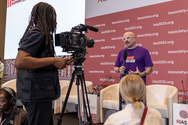 Professional videographer filming a speaker on stage during a corporate live streaming event