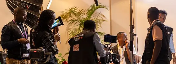 Professional camera crew with studio lighting and boom mic filming a corporate interview